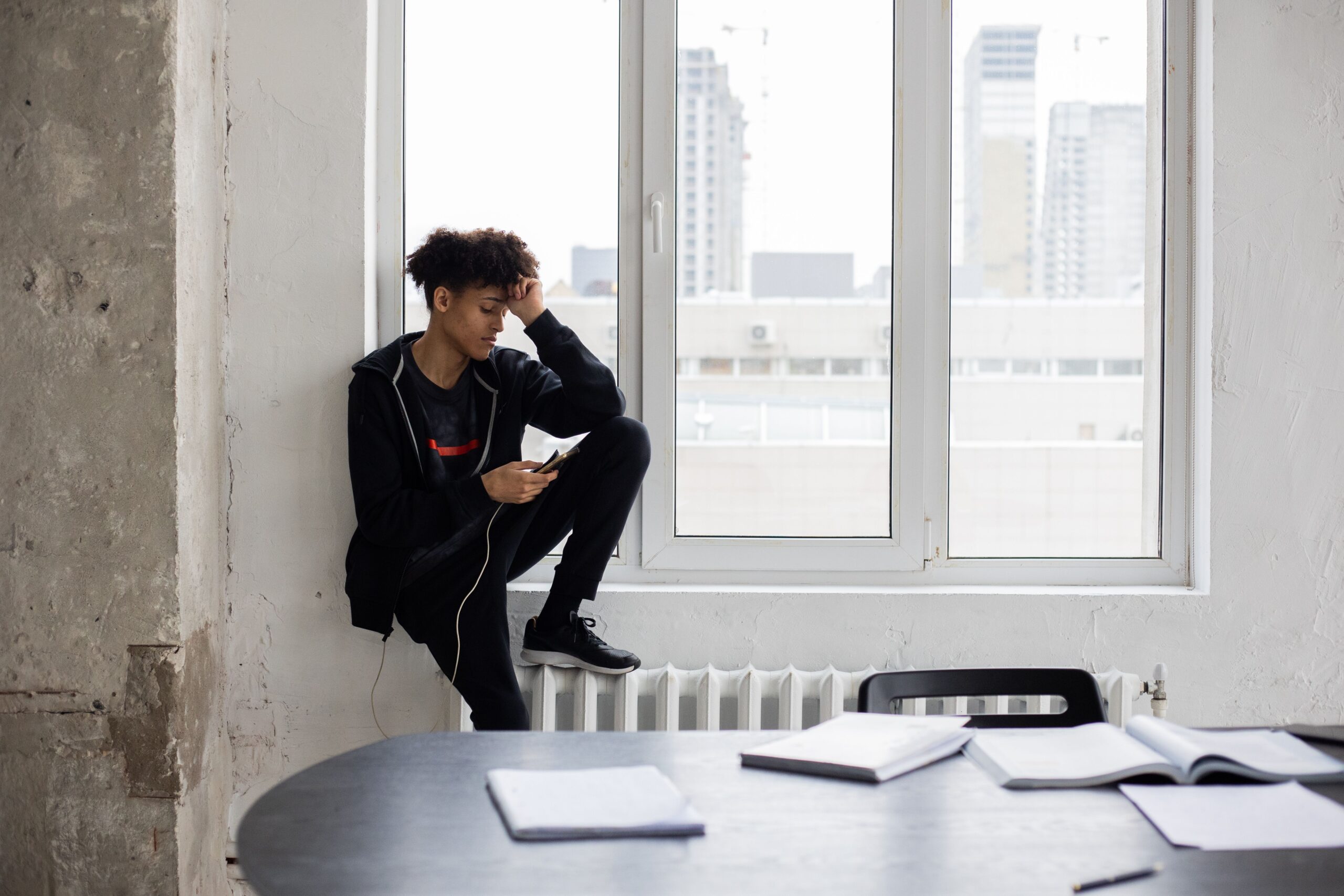 Teenager overthinking while looking at his phone